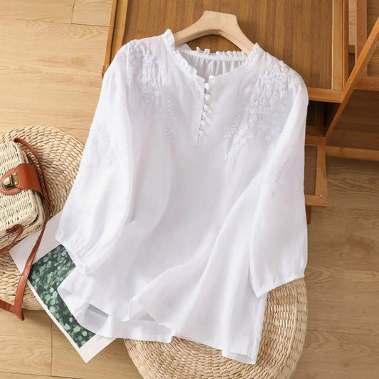 Women's embroidered cotton blouse featuring a classic button-front design, elegant white summer top with detailed embroidery.