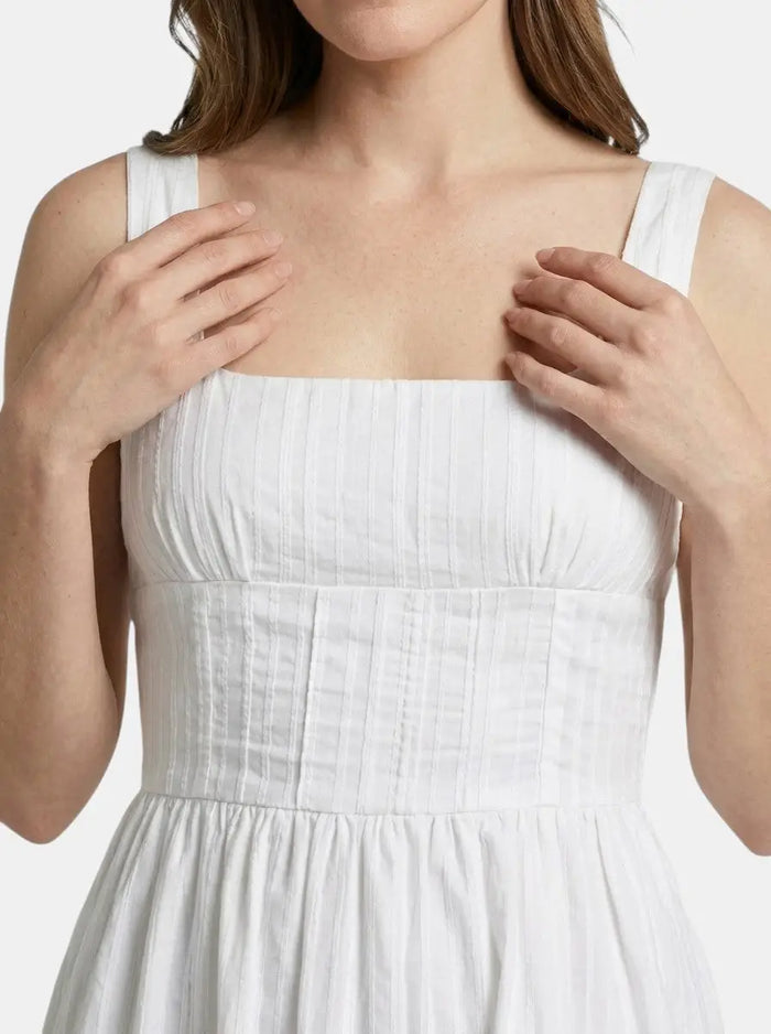 Women's organic cotton white mini summer dress with elegant square neck and ruffle details, perfect for warm-weather wear.