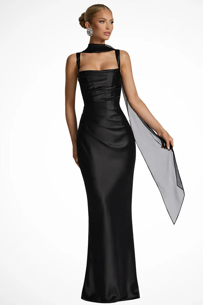 Woman wearing a satin maxi dress with a structured square neckline and ruched design by LondonLaneStore.