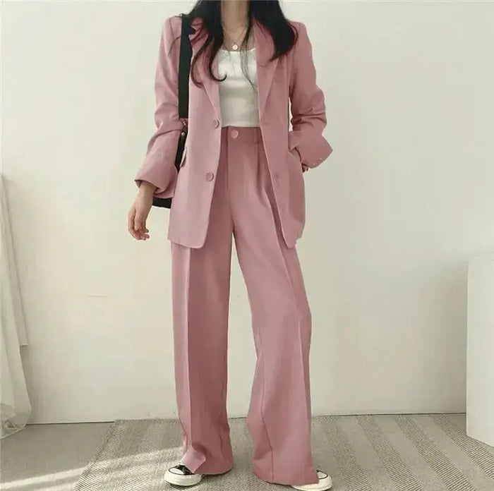 Women's tailored blazer suit set featuring an elegant structured blazer and wide-leg trousers, styled on a model.