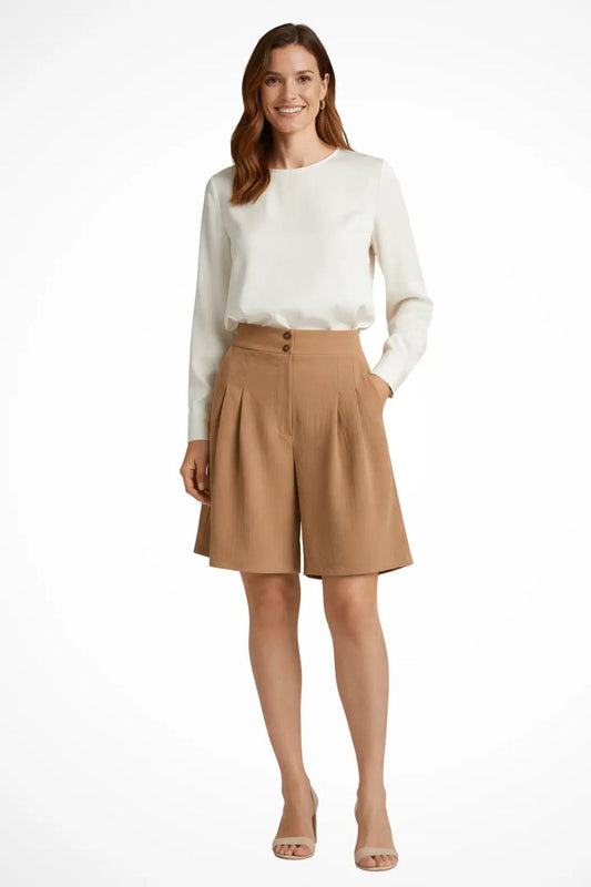 Women’s high waist tailored cotton Bermuda shorts with pleats, stylish summer shorts in a natural pose.