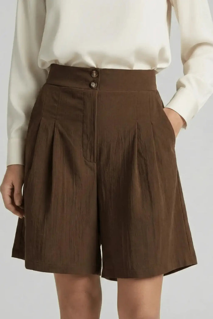 Women's high waist tailored cotton Bermuda shorts with pleated design, stylish summer shorts in a natural pose.